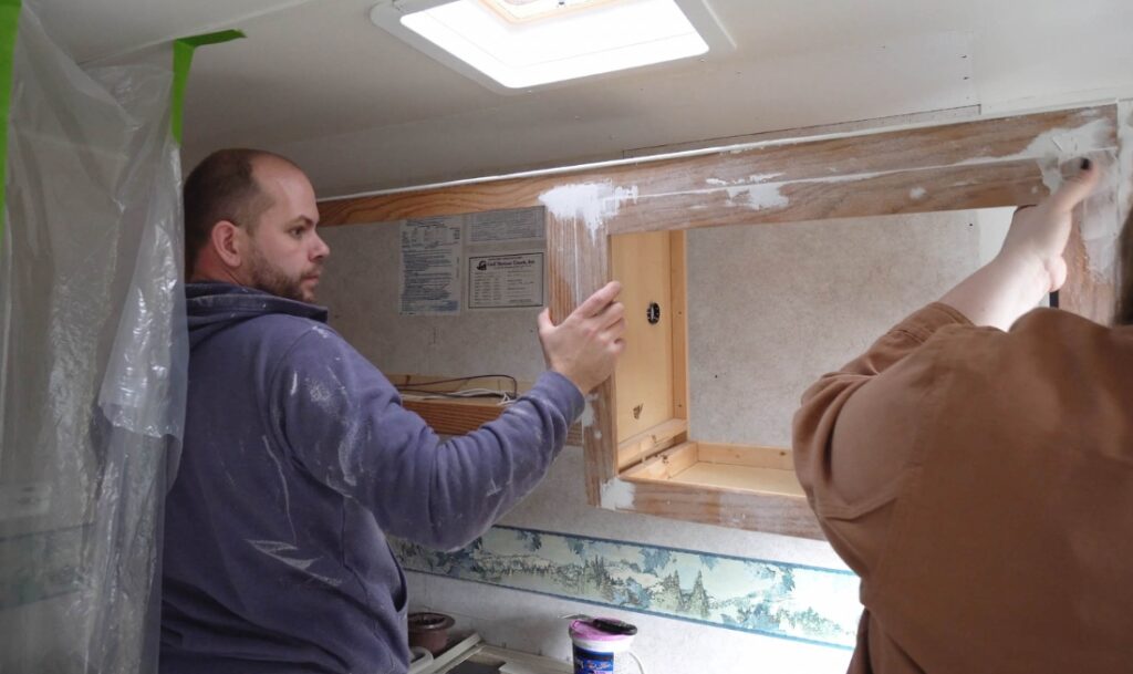 person installing cabinets in rv