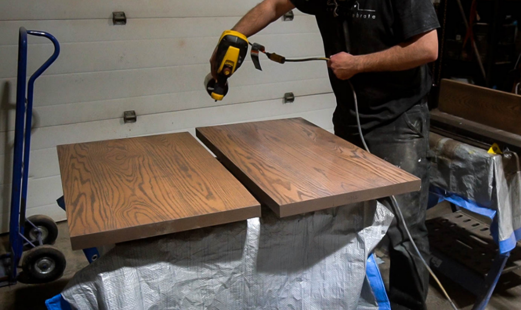 applying top coat to shelves in a garage using a Wagner Paint Sprayer