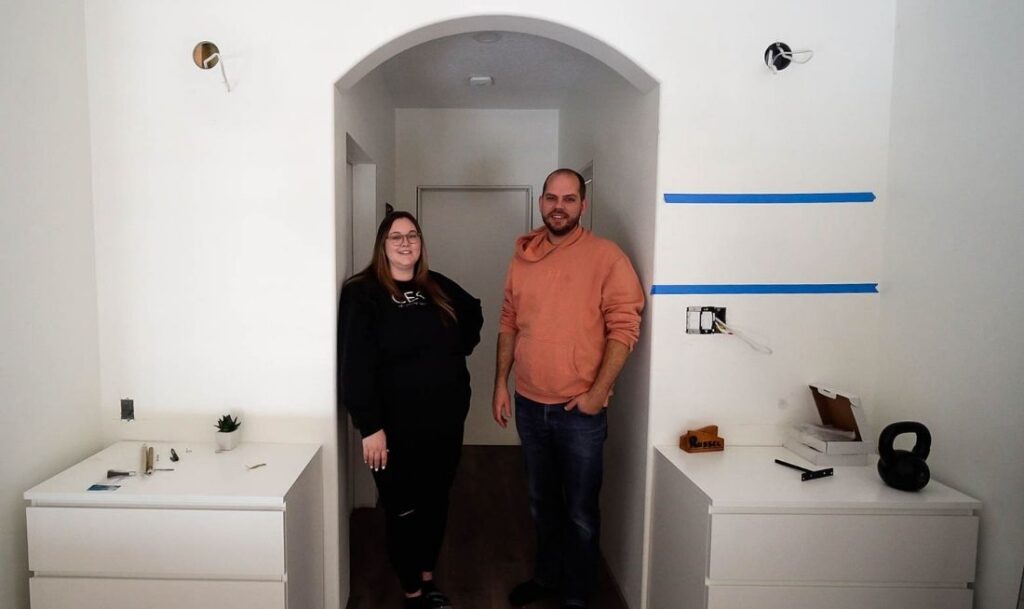 two people standing under an archway inside of their house, ready to get a diy project started