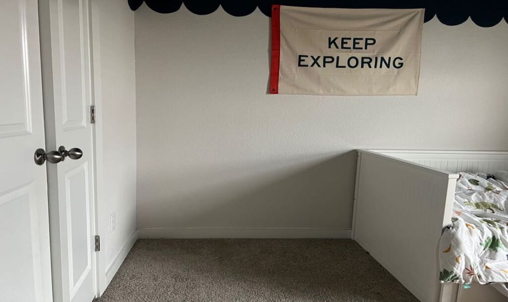 bedroom plain before any renovations, there is a flag that says "keep exploring"