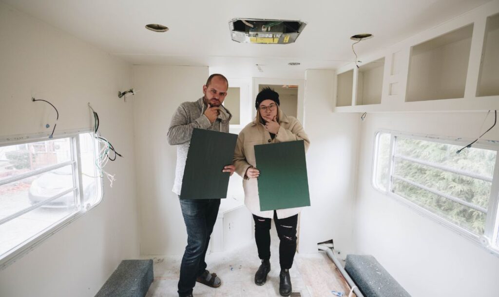 two people inside of an RV holding up paint samples, choosing what color they want to paint the interior of the RV with the Wagner Control Pro 170 paint sprayer