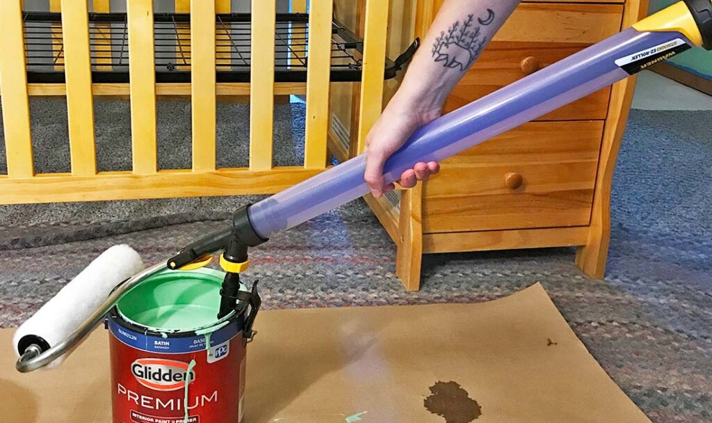 pulling paint into the PaintStick EZ Roller from a paint bucket sitting on the ground