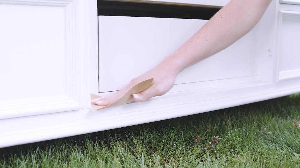 woman sanding dresser 