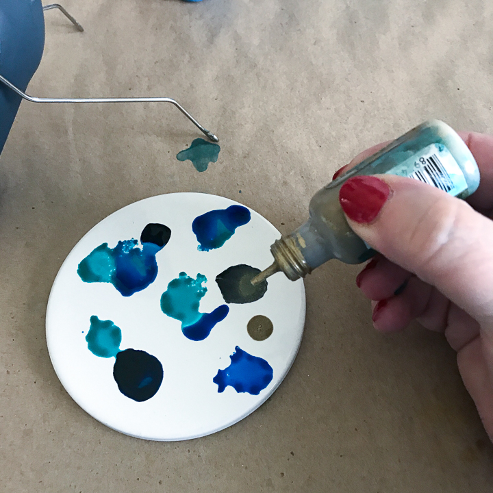 Shake ink and add drops to coasters