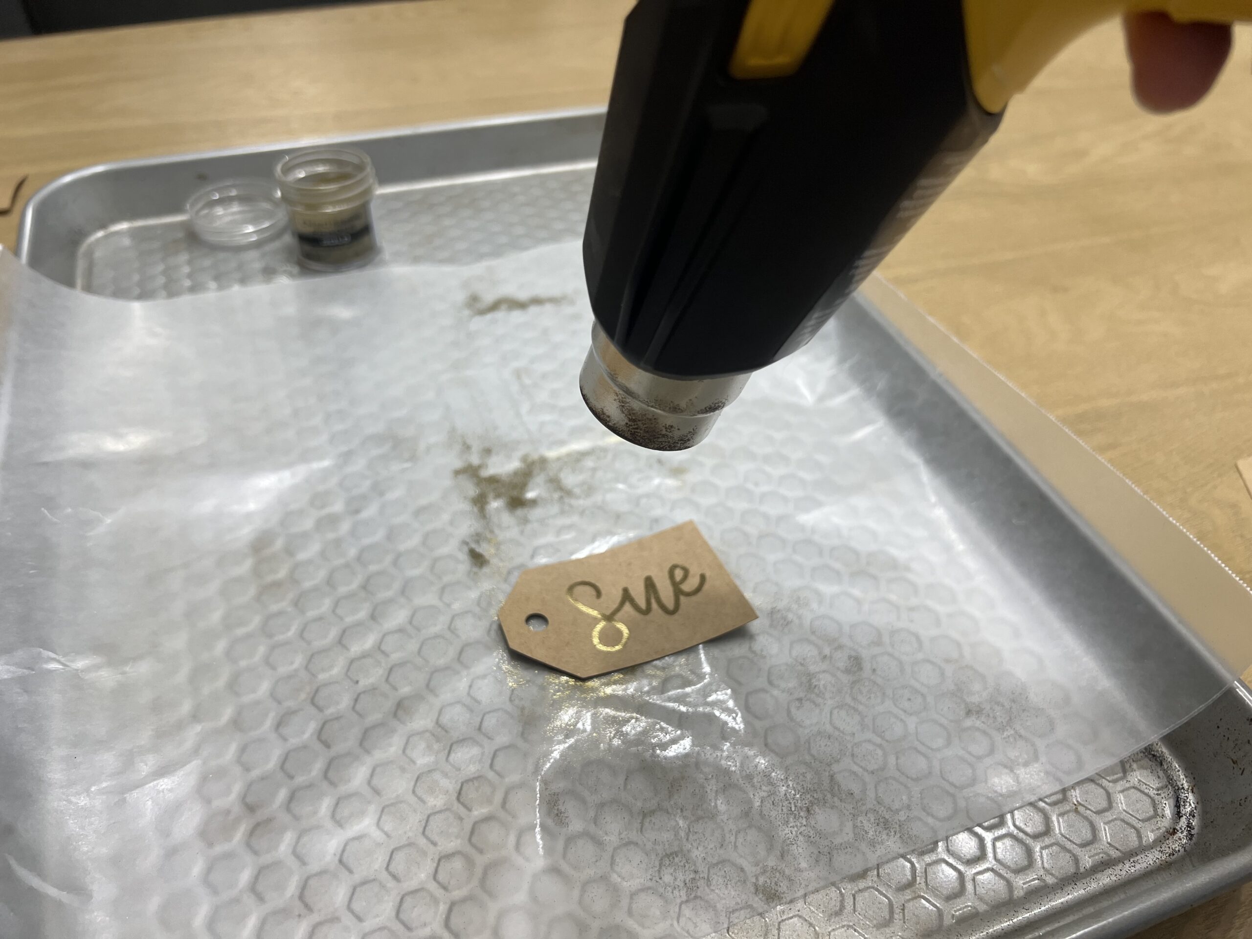Applying heat to embossed tags with heat gun